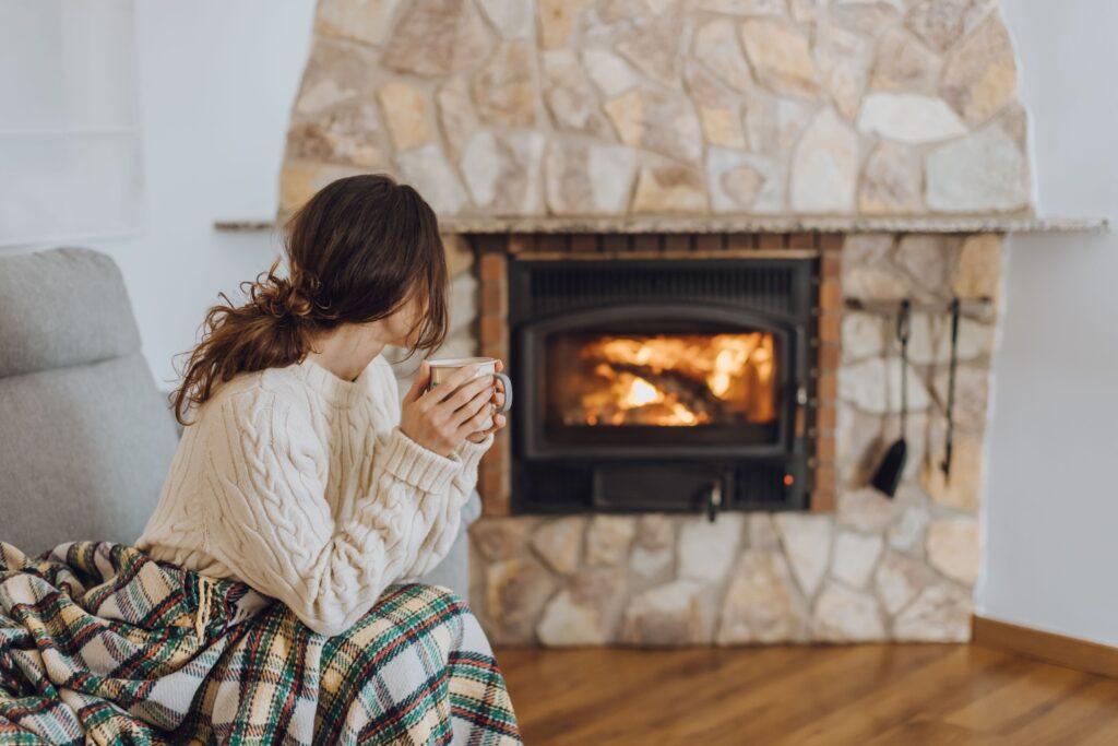 Eine Frau sitzt am Kamin