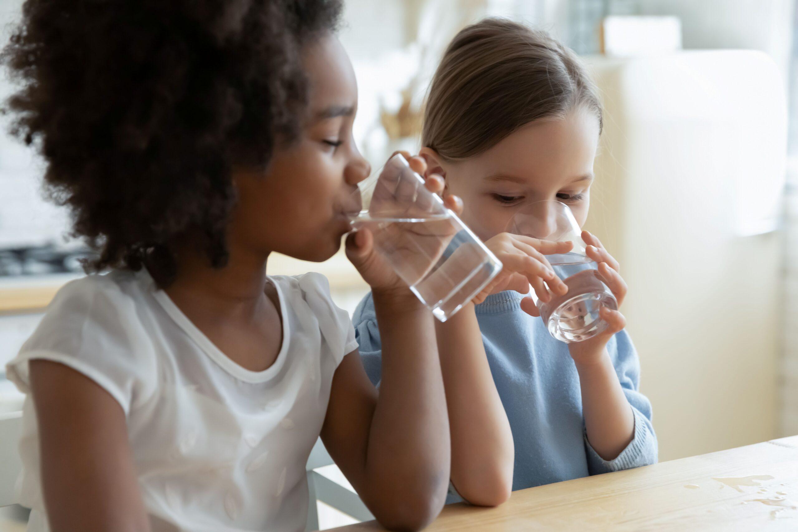 Zwei Kinder trinken Wasser